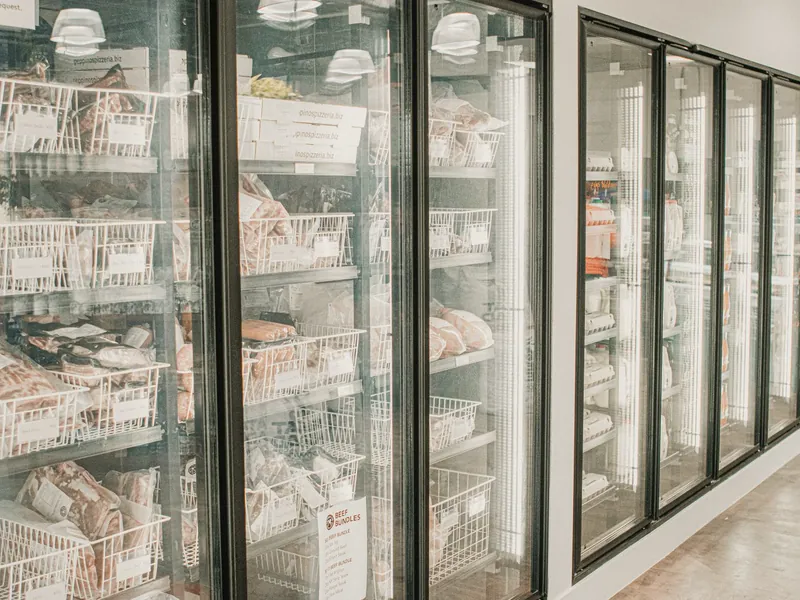 Freezers verticais com portas de vidro em um corredor de supermercado